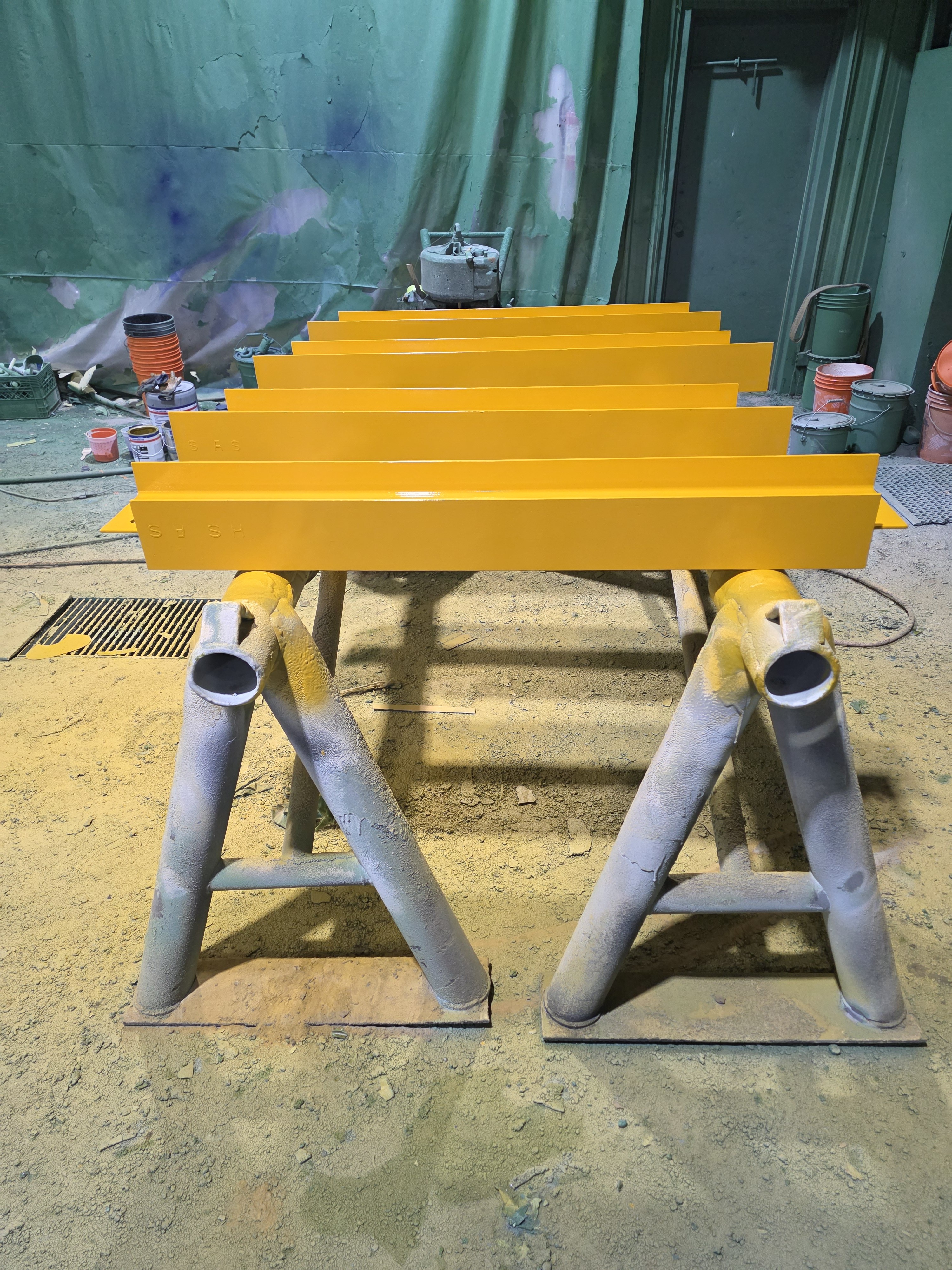 Industrial structural steel components with precision yellow safety guard coating and primer application