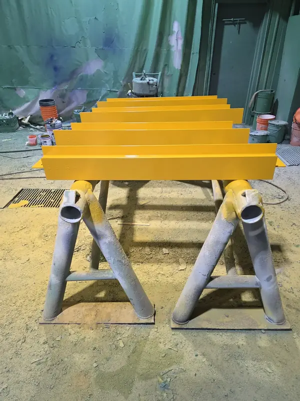 Industrial structural steel components with precision yellow safety guard coating and primer application
